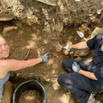 Grad students Emma Weikert and Brooke Ayers point to a nearly whole 19th century cream pan