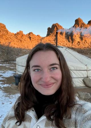 Image of a woman standing in front of a Mongolian yurt.